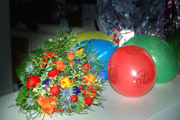 Geschenketisch mit Blumen und Luftballon